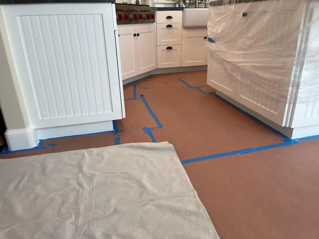 Kitchen floor covered with protective paper during painting process.