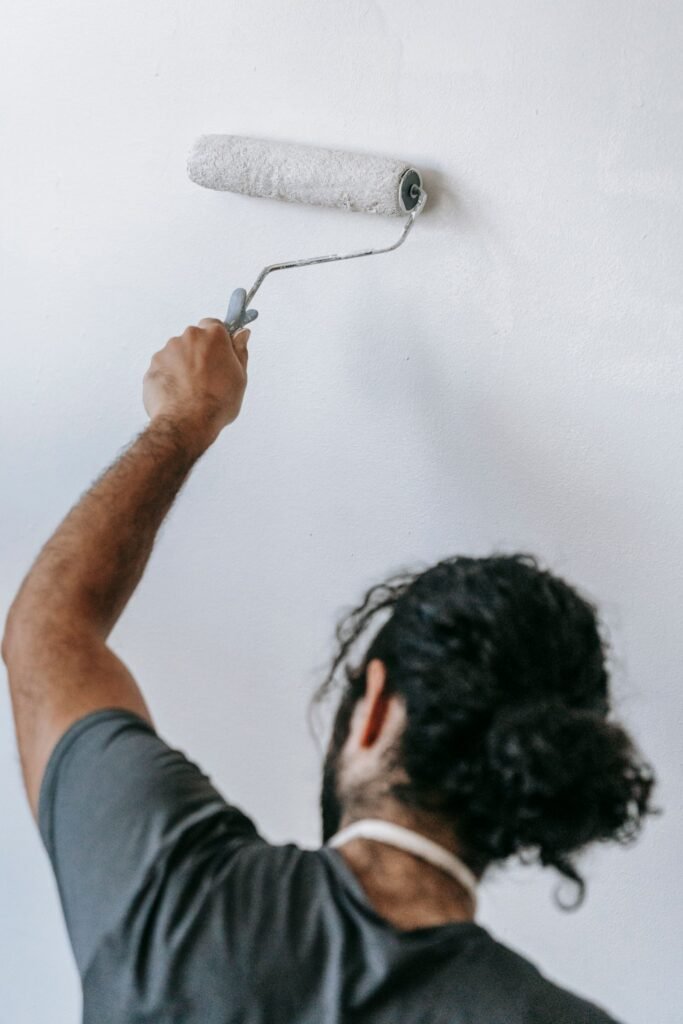 Illustrative photo: carefully painting a prepared interior wall